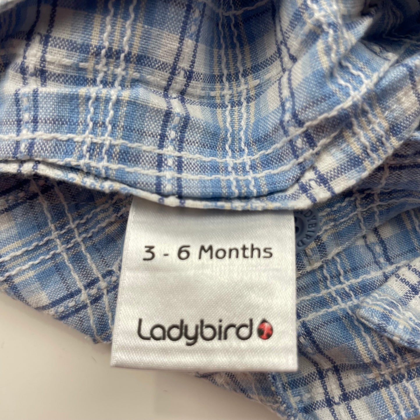 Blauer Baumwoll-Overall mit kariertem Muster und Taschen. – label