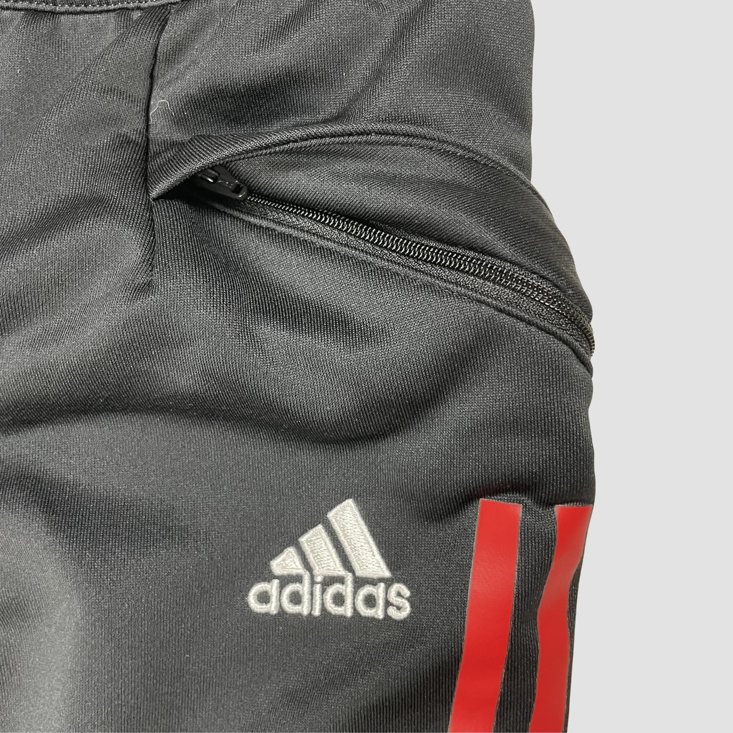 Schwarze Kinder-Trainingshose mit weißen und roten Seitenstreifen und Vereinslogo, Größe 152 – pocket