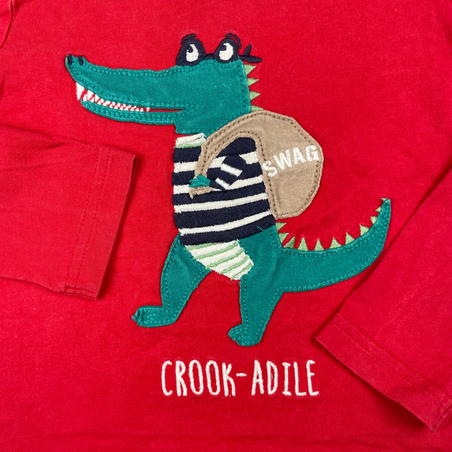 Rotes Langarmshirt mit Krokodil-Applikation vorne – detail