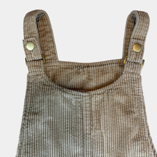 Beiges Cord-Latzkleid für Kinder mit Knopfträgern und seitlichen Taschen – detail