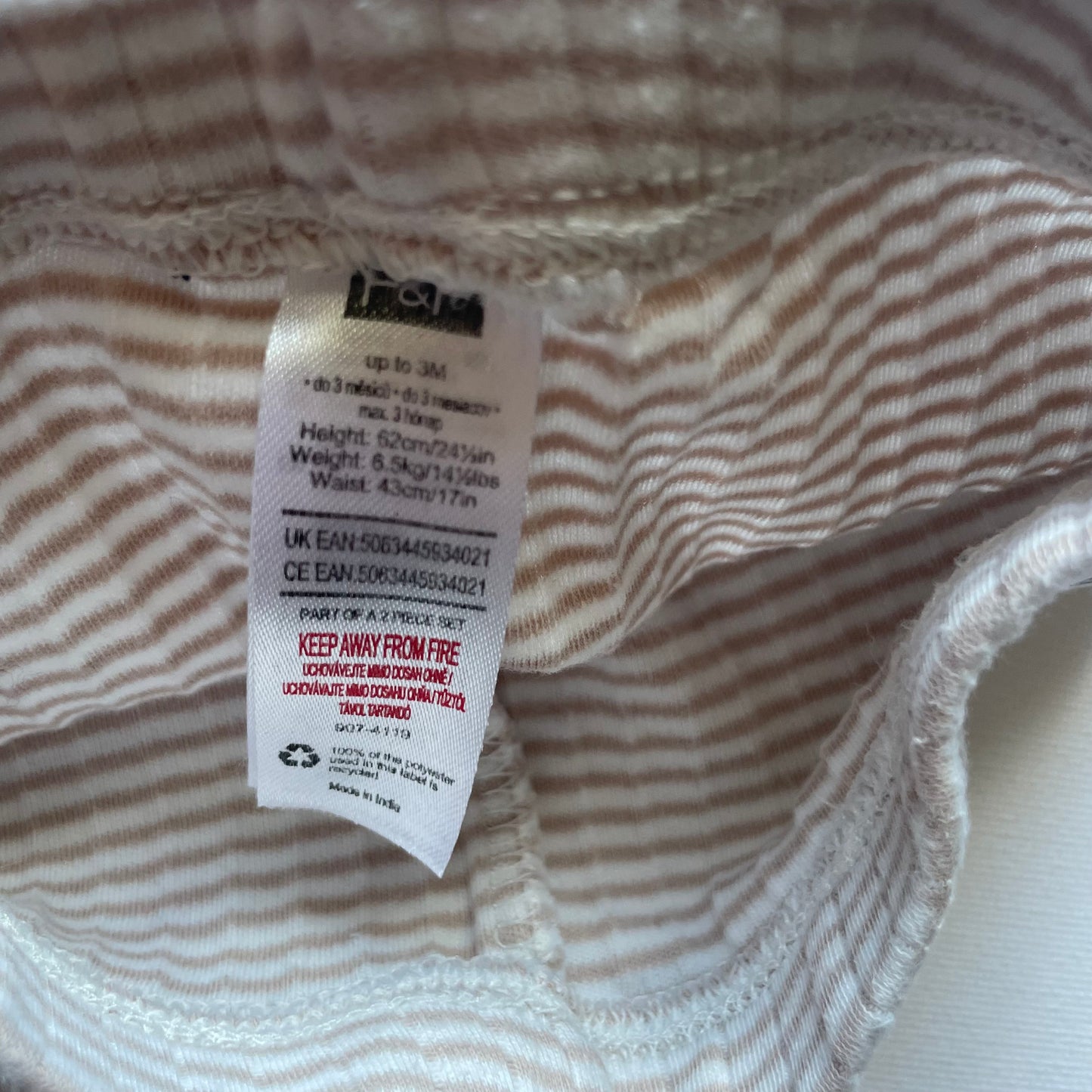 Graue Stramplerhose aus Baumwolle für Babys bis 3 Monate. Hellgraues Streifenmuster mit Füßen, passend für alle Jahreszeiten. – label