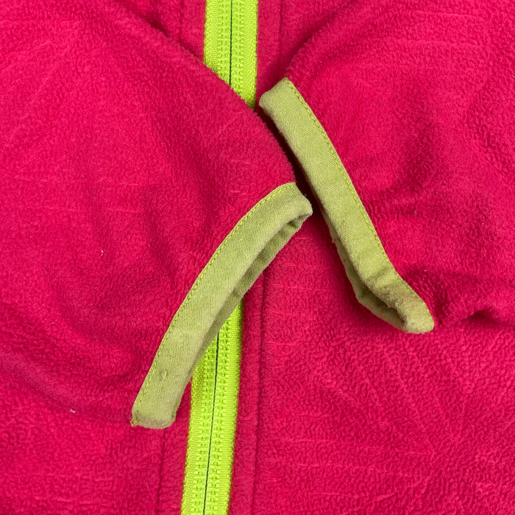 Rosa Kinder-Kapuzenjacke mit grünen Kontrasten, Reißverschluss, Taschen und Daumenlöchern – detail