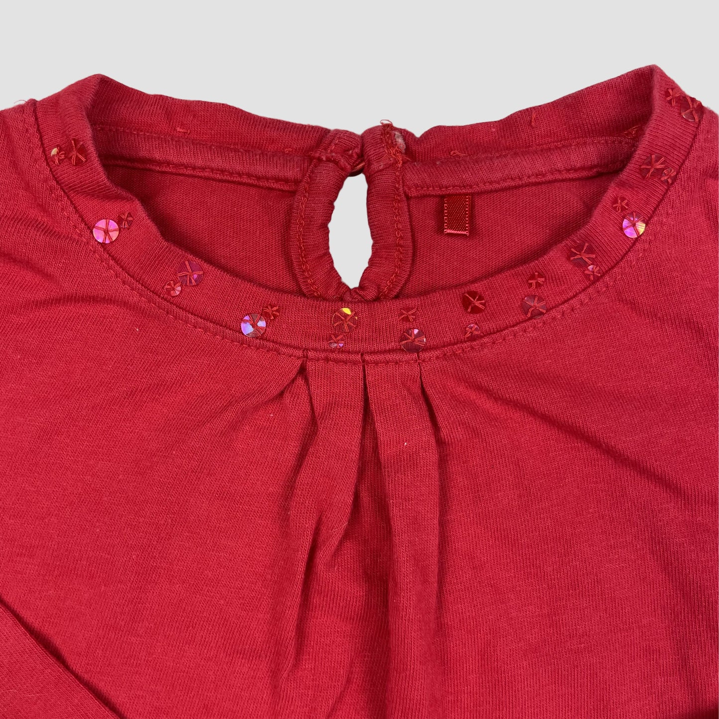 Rotes Langarmshirt von George aus Baumwolle mit Pailletten am Ausschnitt und kleiner Tasche mit Schleife, Größe 3–4 Jahre (98–104 cm) – detail