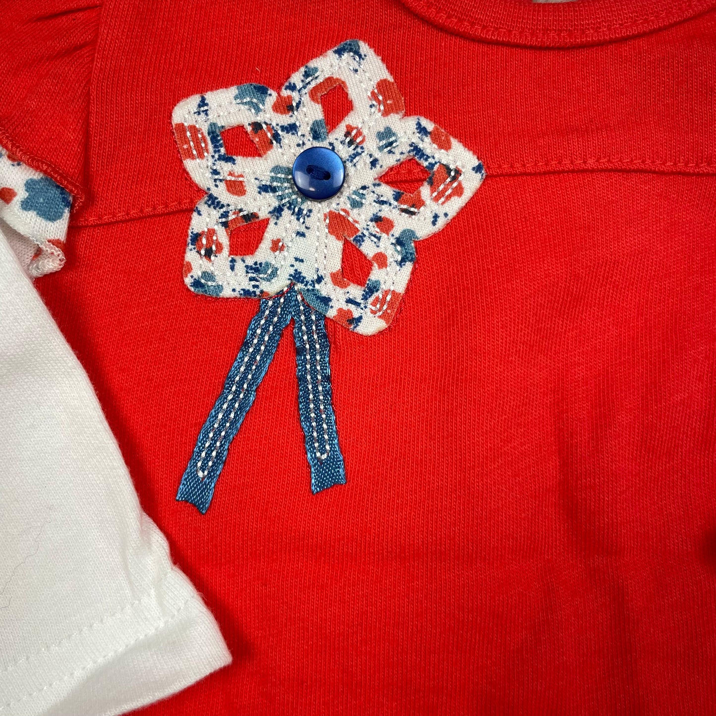 Rotes Baby-Kleid von M&Co mit weißen langen Ärmeln, Blumenapplikation und Rüschen-Saum – detail