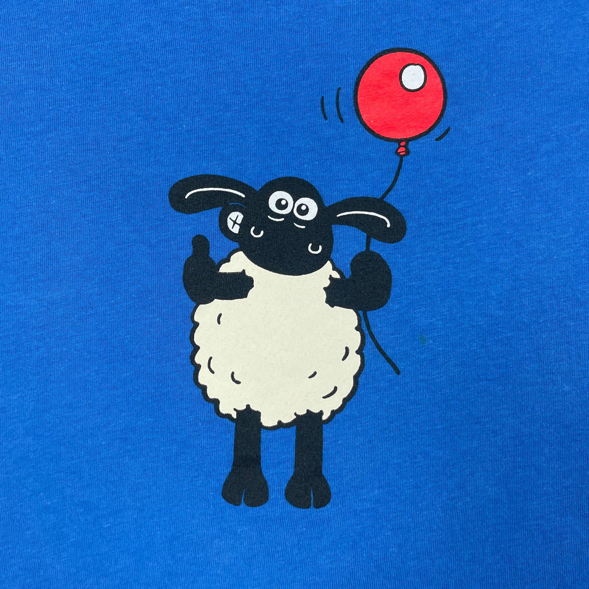 Blaues Kinder-T-Shirt mit Shaun das Schaf und rotem Ballon – detail
