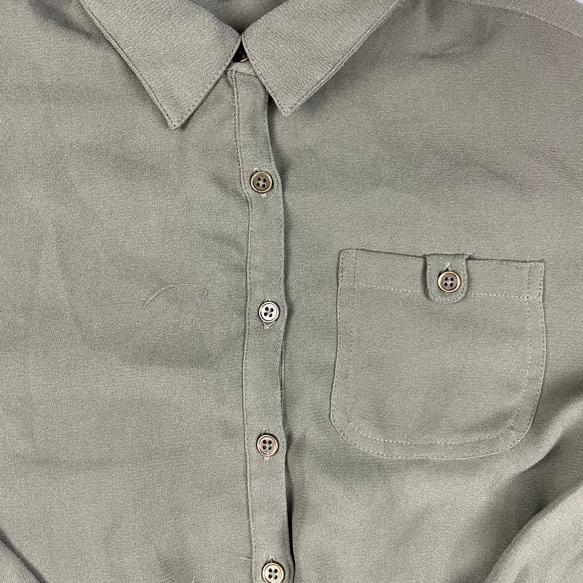 Grüner Kinder-Overall mit langen Ärmeln und kurzen Beinen, Knopfleiste, Brusttasche und seitlichen Taschen – detail