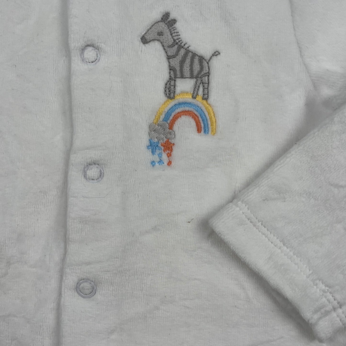 Weiße Jacke mit Zebra-Motiv und Knopfleiste für Babys. – detail