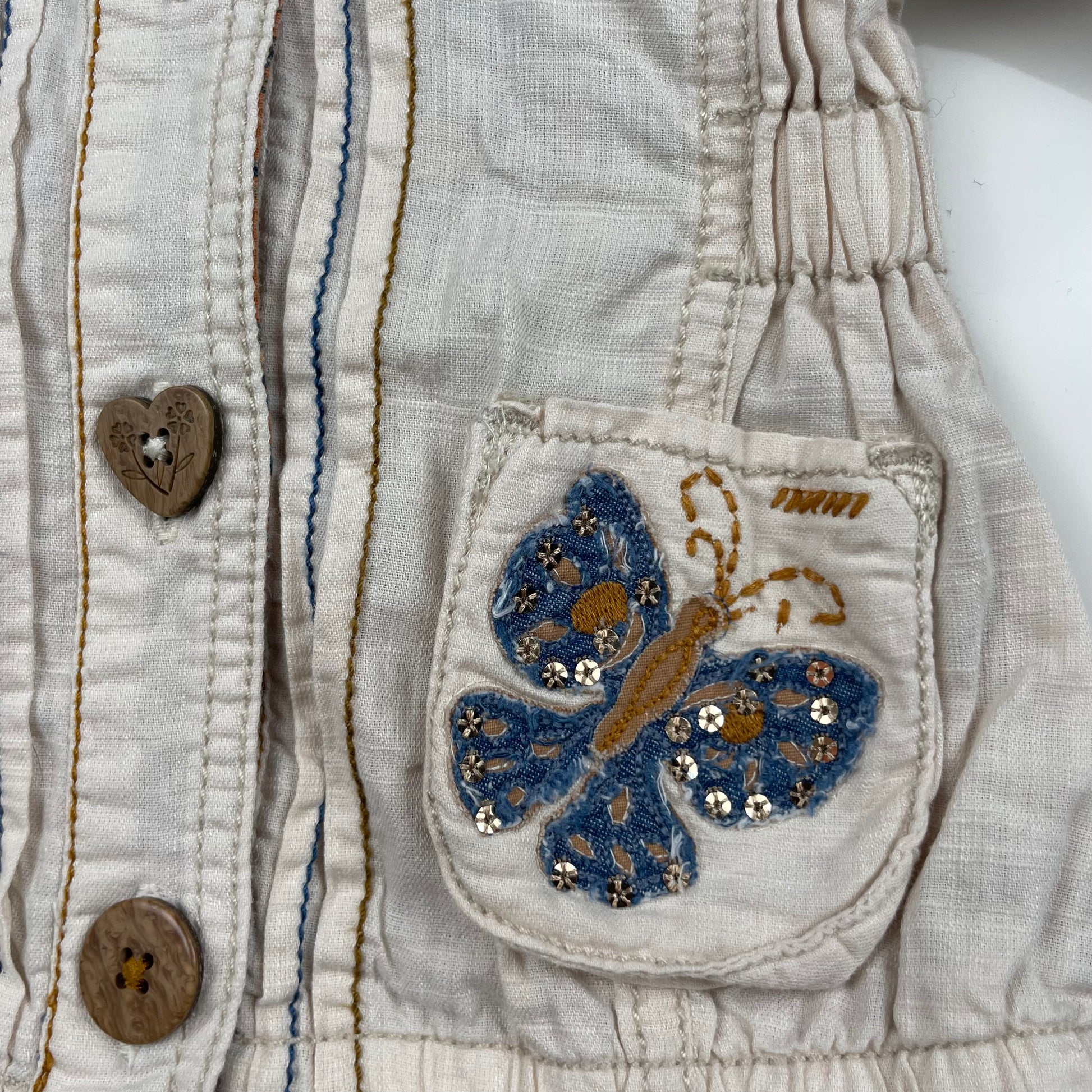 Beige Kapuzenjacke mit Schmetterlingsmotiven auf den Taschen – pocket