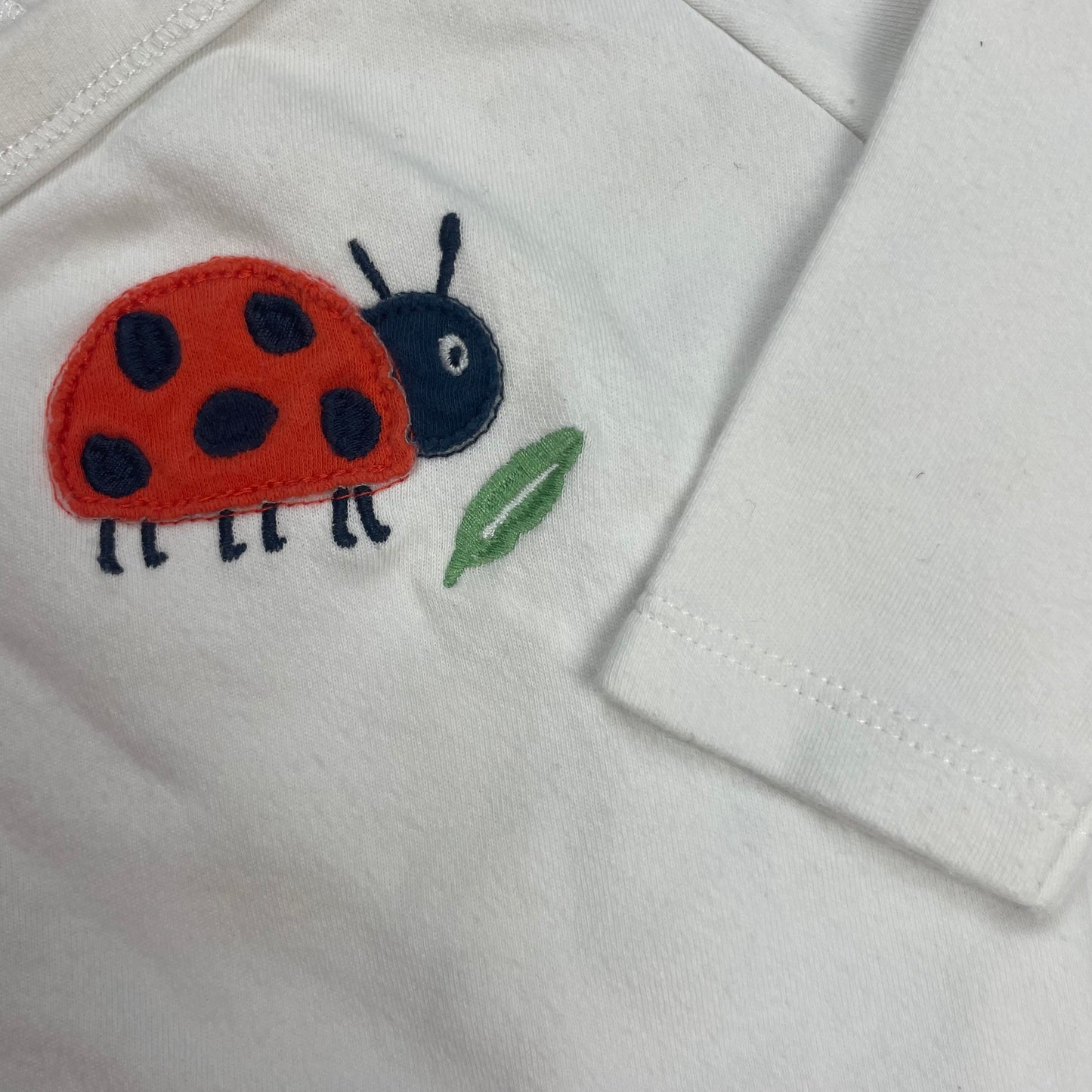 Weißer Baby-Kimono mit Marienkäfer-Applikation auf der Vorderseite – detail