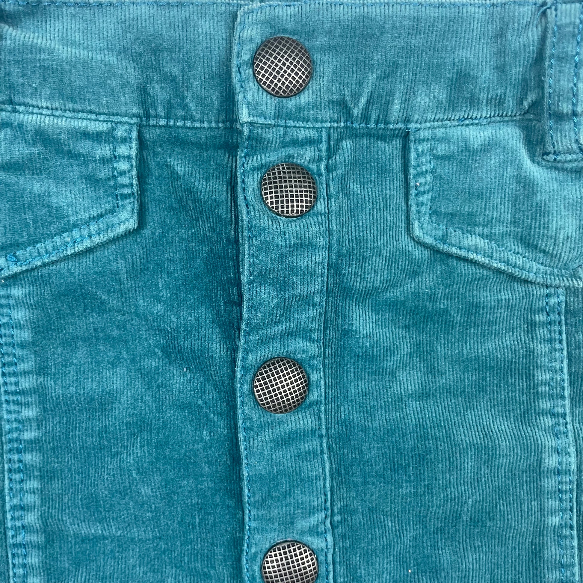 Blauer Cordrock mit Knopfleiste und Taschenklappen vorne. – detail