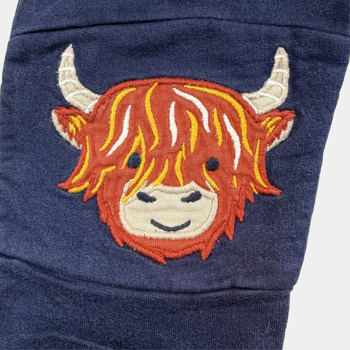 Dunkelblaue Kinder-Sweathose mit Kuh-Stickereien auf den Knien – fabric