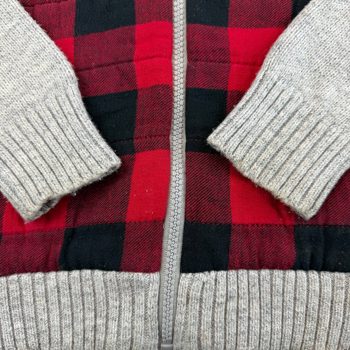 Rote und schwarze karierte Kinder-Strickjacke mit grauen Ärmeln und Reißverschluss – detail