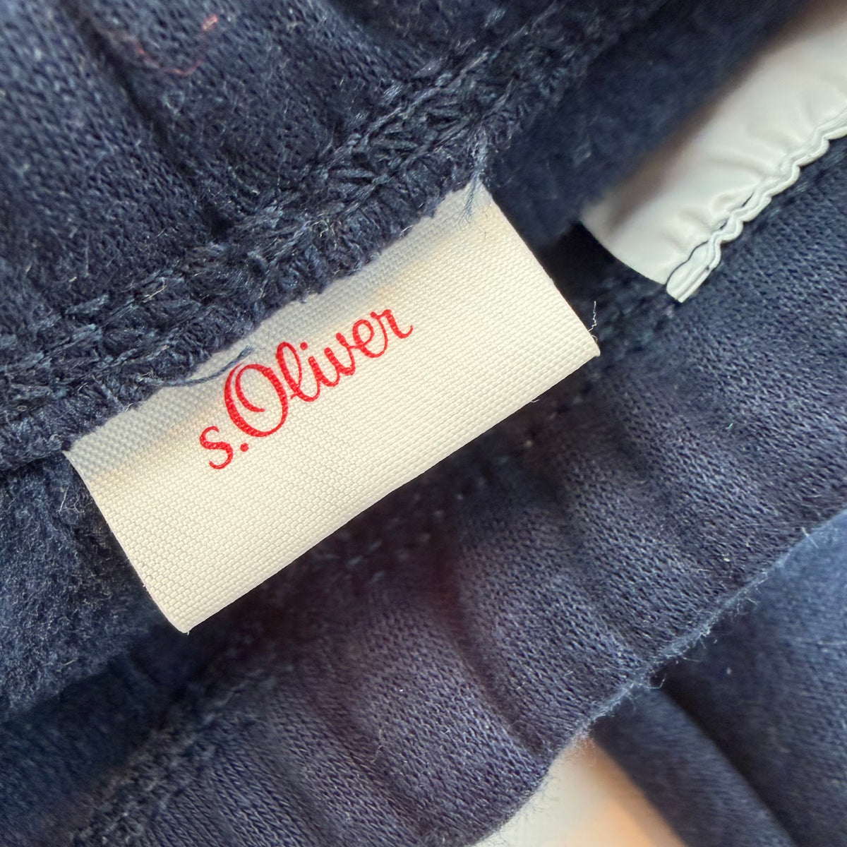 Dunkelblaue Baby-Sweathose mit roten Seitenstreifen – label