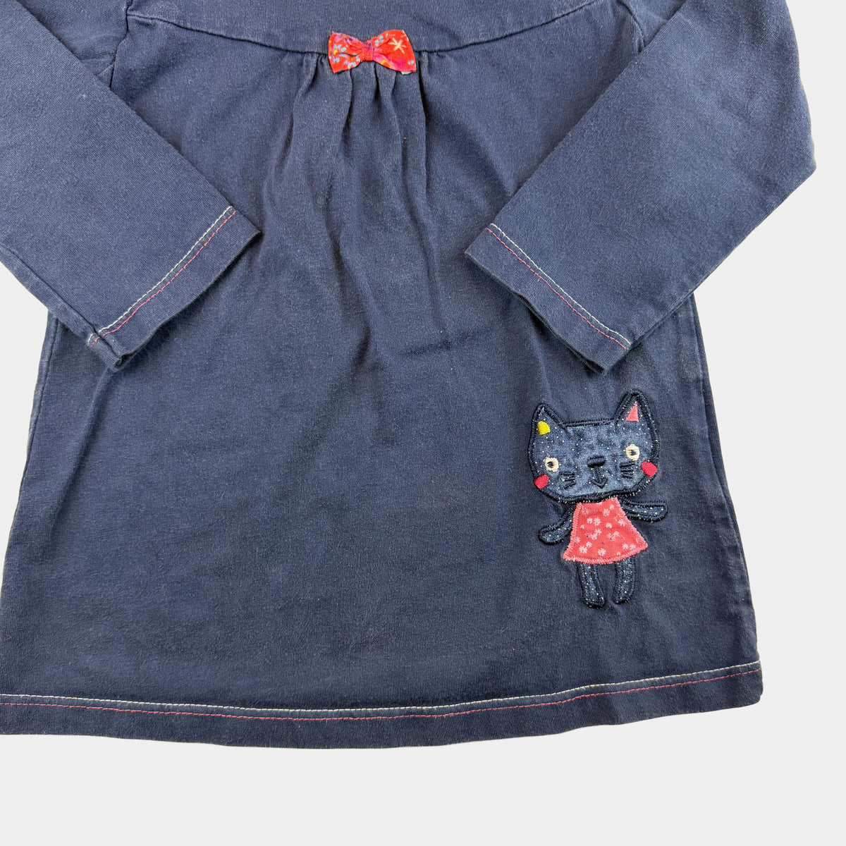 Blaues Kinderkleid mit langen Ärmeln, Schleife und Katzen-Applikation – detail
