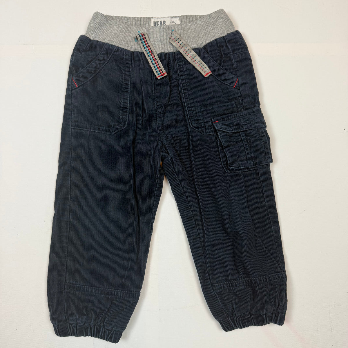 Dunkelblaue Cordhose für Kinder mit grauem Bund, Cargo-Tasche und roter 03-Stickerei, Größe 86 – front