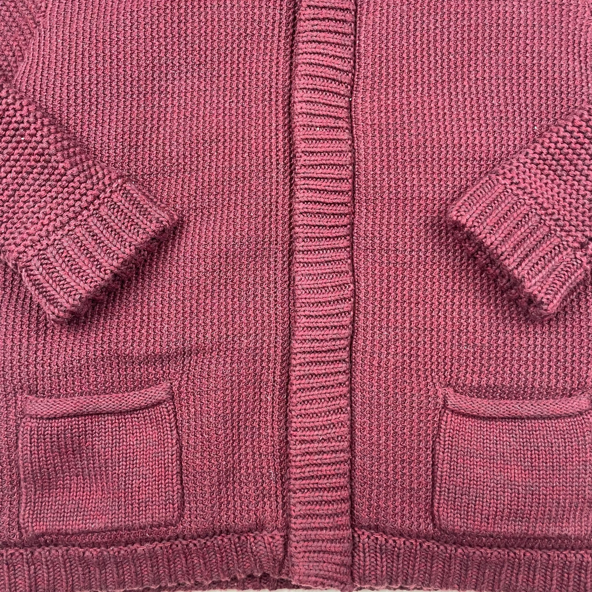 Bordeauxfarbene Kinder Strickjacke mit Kapuze und Taschen. – detail
