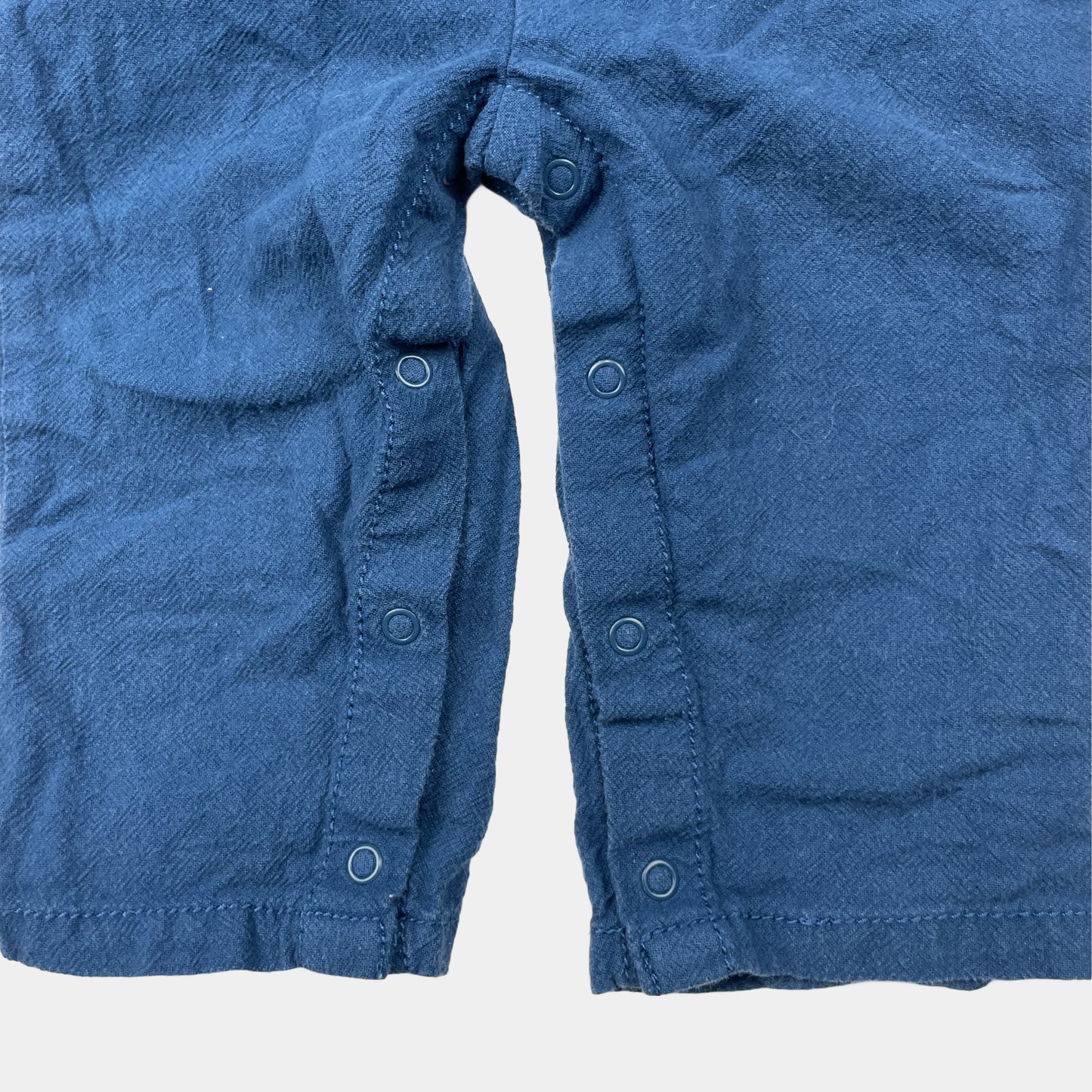 Blauer Overall mit Dinosaurier-Stickerei und Knöpfen – close‑up