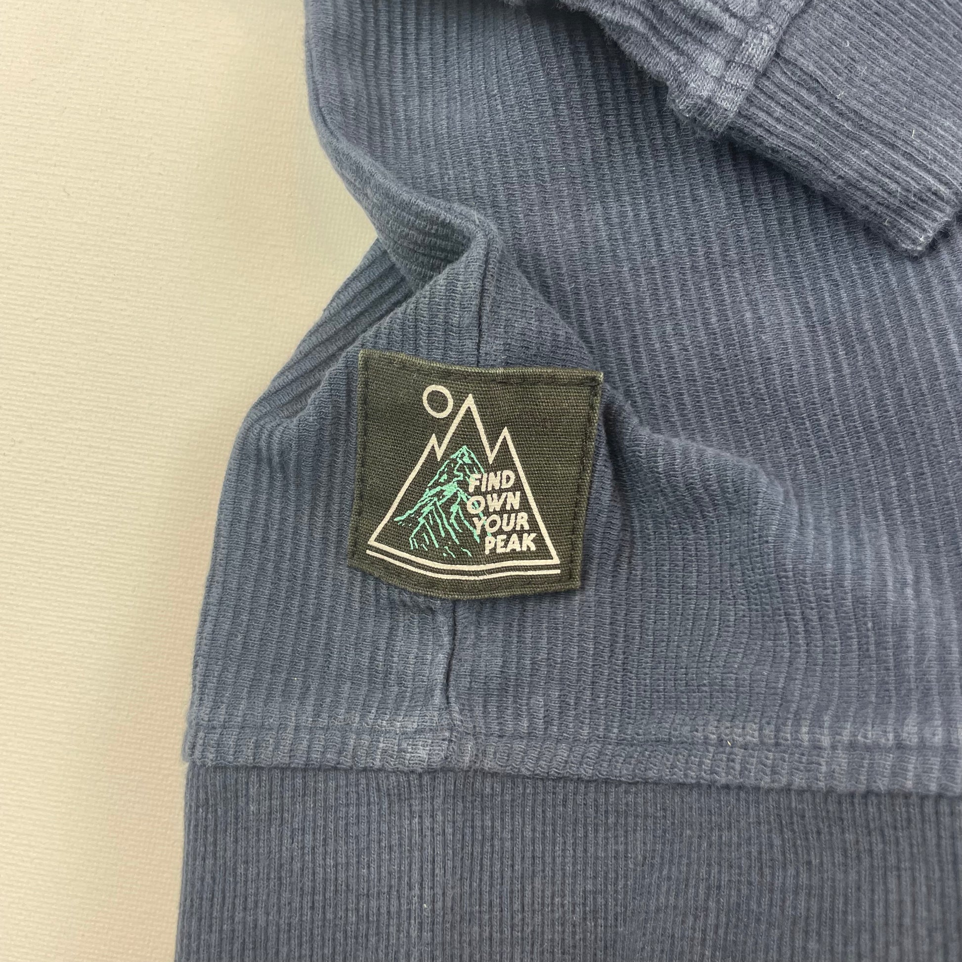 Dunkelblauer Baumwoll-Pullover mit Rippstruktur und kleiner Brusttasche – detail