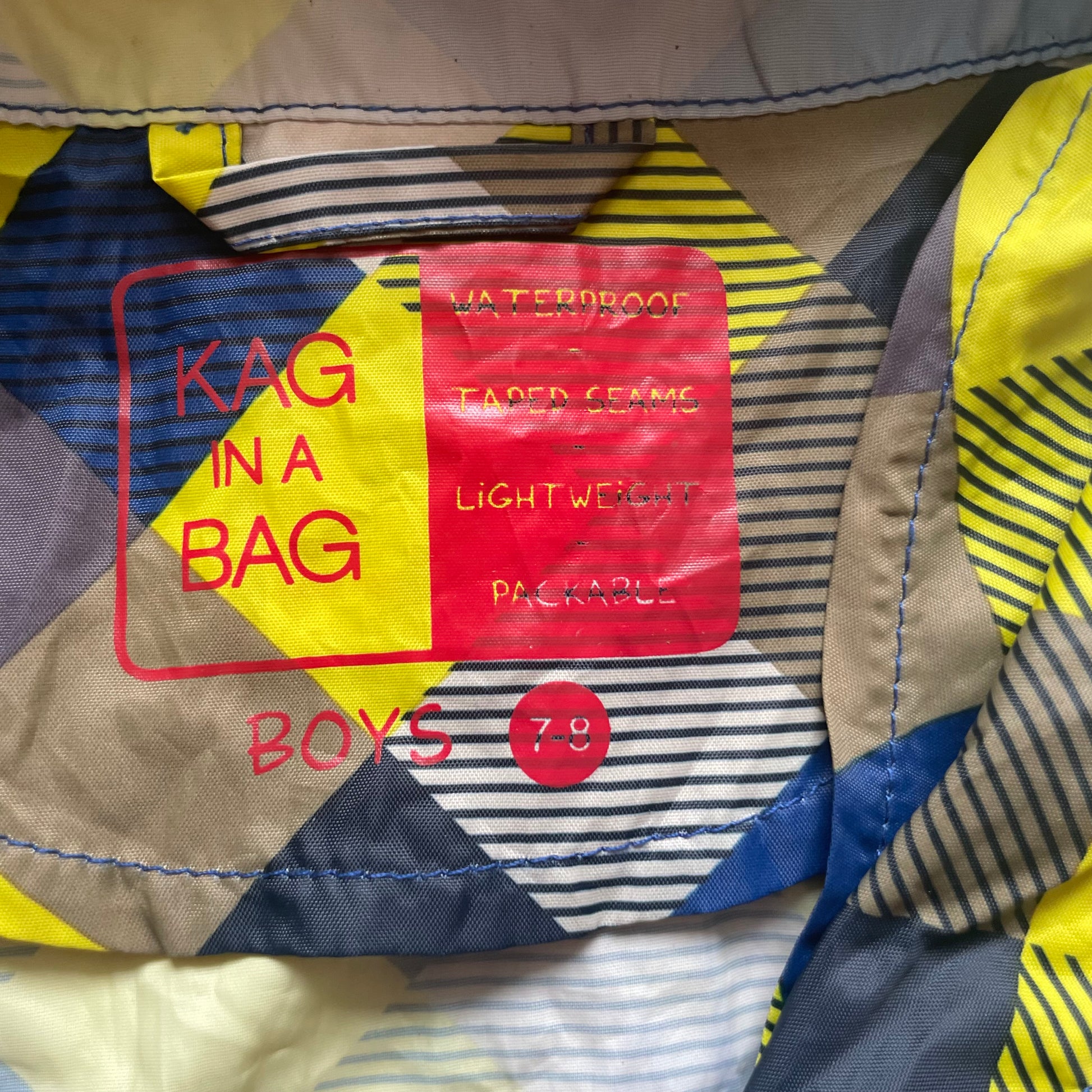 Mehrfarbige Regenjacke mit Kapuze und quadratischem Muster – label