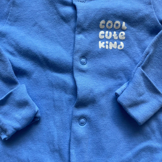 Blauer Baby-Overall mit Aufdruck "Cool Cute Kind" und Druckknöpfen. – detail