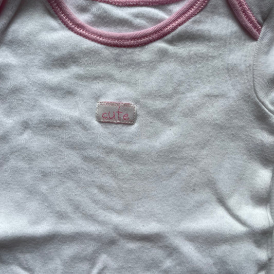 Weißer Babybody von George mit rosa Paspeln. – detail