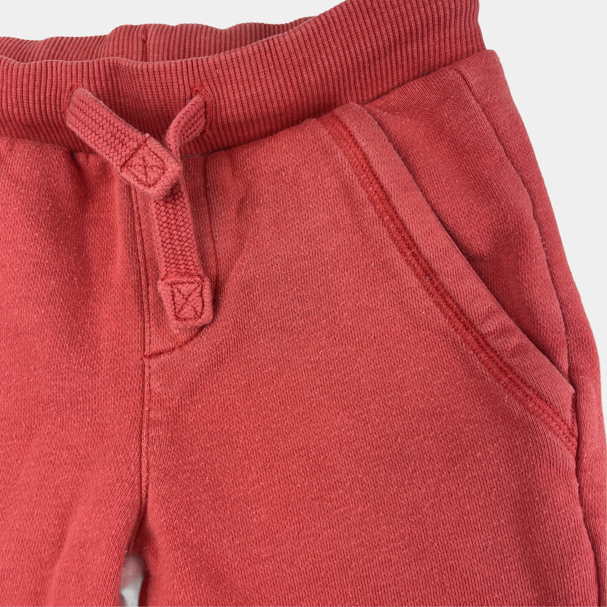 Rote Baumwoll-Jogginghose mit elastischem Bund und Seitentaschen. – detail