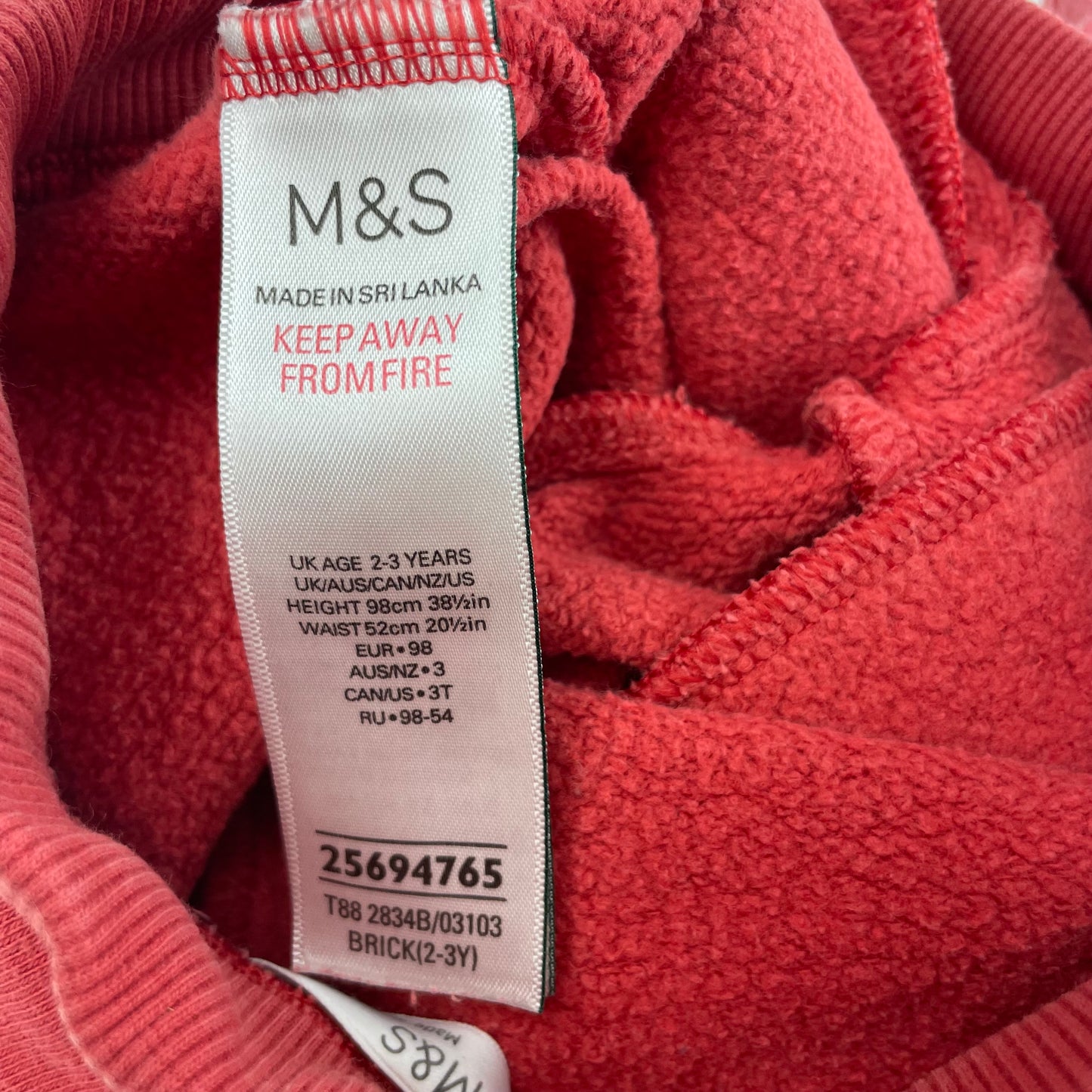 Rote Baumwoll-Jogginghose mit elastischem Bund und Seitentaschen. – label