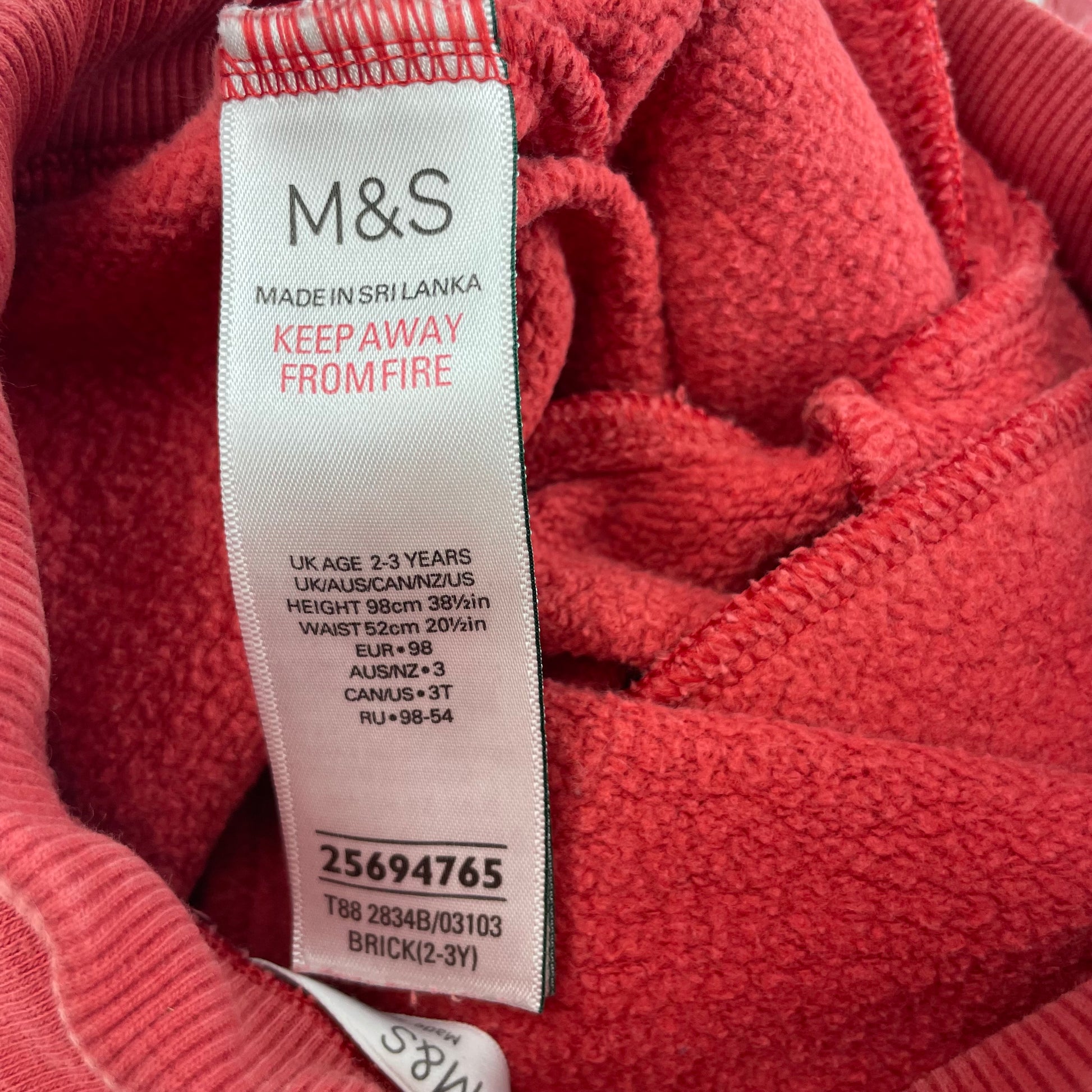 Rote Baumwoll-Jogginghose mit elastischem Bund und Seitentaschen. – label